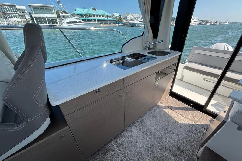Slide: The Image of Interior of 2026 Jeanneau NC 1095 Coupe Series 2 with modern kitchenette and scenic view. - 27