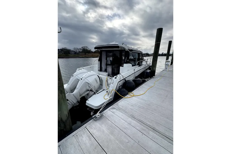 Slide: The Image of 2026 Jeanneau NC 1095 Coupe Series 2 docked, featuring dual outboard engines. - 3