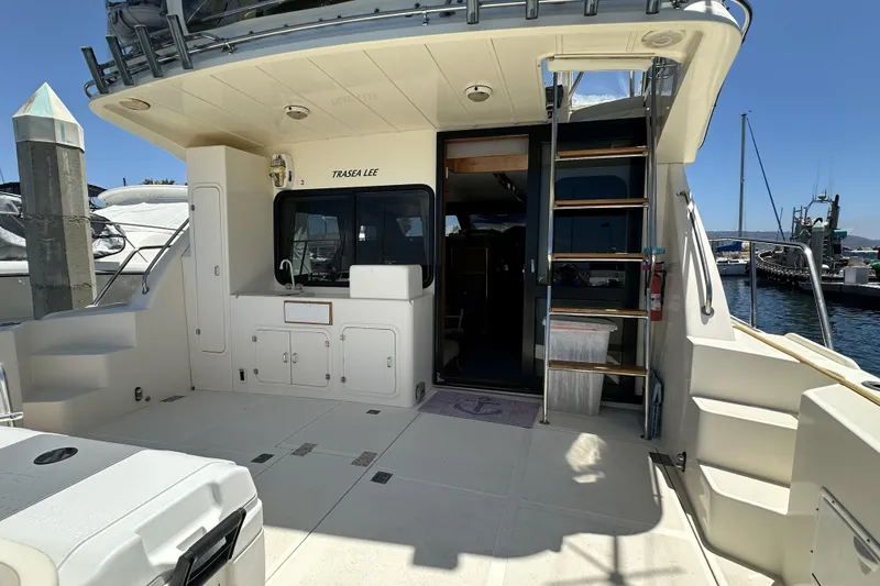 Slide: The Image of 1998 Mikelson 43 Sportfisher yacht deck with ladder and marina view. - 9