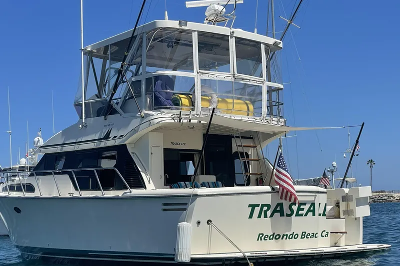 Slide: The Image of 1998 Mikelson 43 Sportfisher yacht docked, displaying American flags, clear sky background. - 3