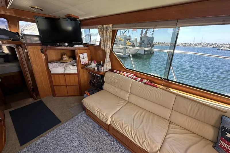 Slide: The Image of Interior of 1998 Mikelson 43 Sportfisher yacht with beige sofa and waterfront view. - 17