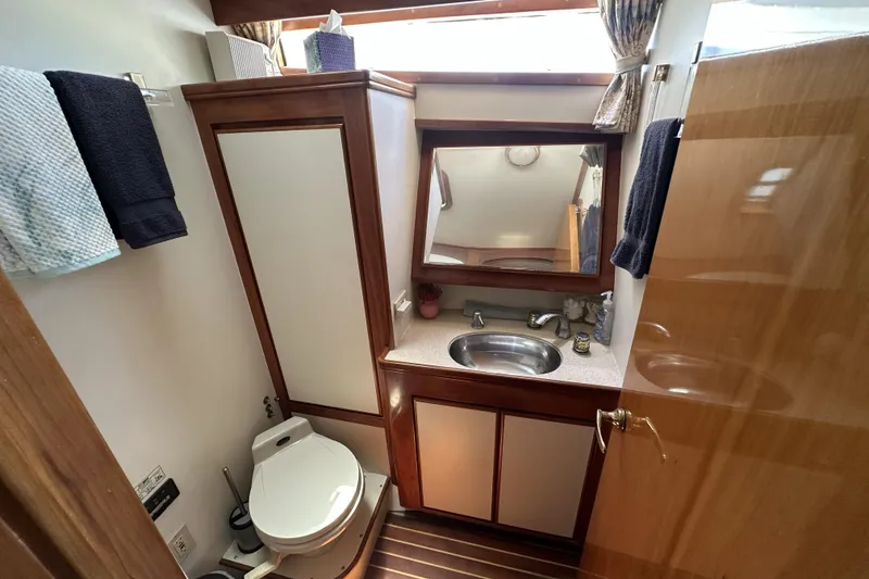 Slide: The Image of Bathroom interior of a 1998 Mikelson 43 Sportfisher yacht with sink and toilet. - 16