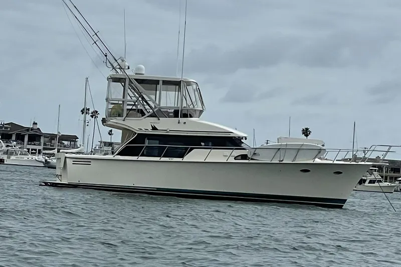 Slide: The Image of 1998 Mikelson 43 Sportfisher yacht docked in a marina, overcast sky. - 5