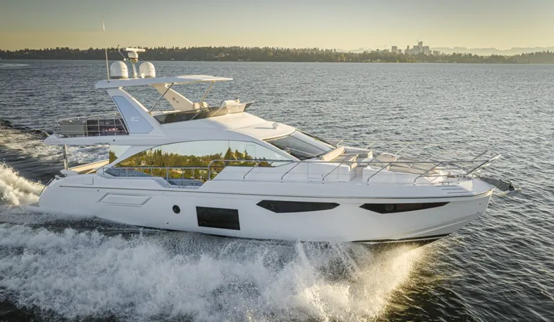 Slide: The Image of The 2023 Azimut 60 Fly cruising on the water with a city skyline in the background. - 5