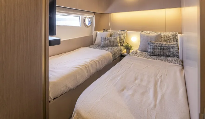 Slide: The Image of Interior of the 2023 Azimut 60 Fly with two single beds and a window. - 14