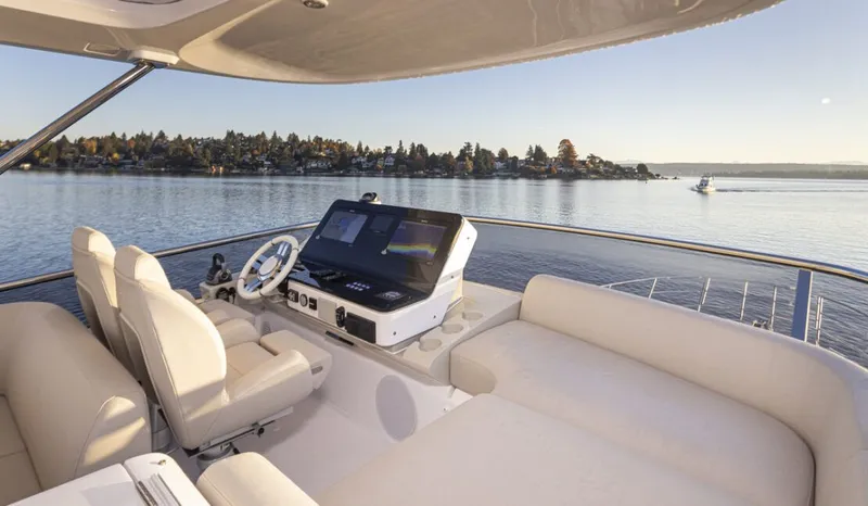 Slide: The Image of The image shows the helm of a 2023 Azimut 60 Fly overlooking calm waters. - 10