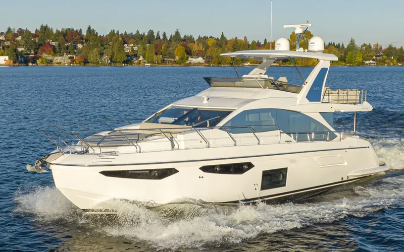 Slide: The Image of 2023 Azimut 60 Fly on a calm lake with a wooded shoreline in the background. - 4