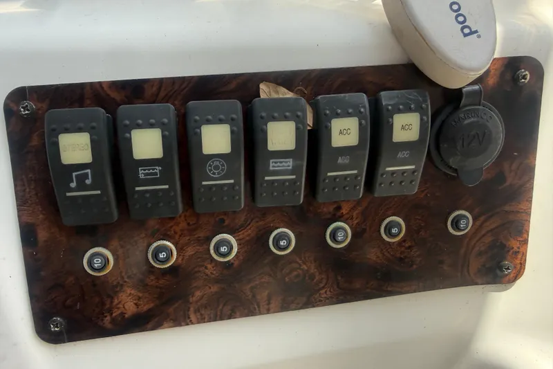 Slide: The Image of Control panel of a 2012 Hurricane SunDeck Sport 188 OB boat with switches and 12V outlet. - 10