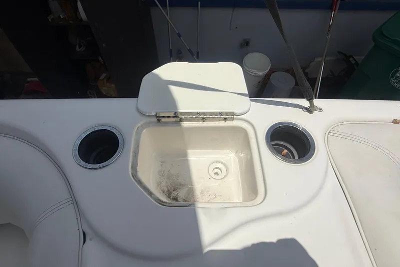 Slide: The Image of 2012 Hurricane SunDeck Sport 188 OB boat interior with cup holders and storage compartment. - 12