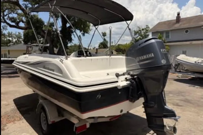 Slide: The Image of 2012 Hurricane SunDeck Sport 188 OB boat with Yamaha outboard motor, parked outdoors. - 1