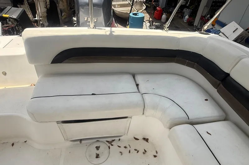 Slide: The Image of 2012 Hurricane SunDeck Sport 188 OB boat interior with white seating and scattered leaves. - 5