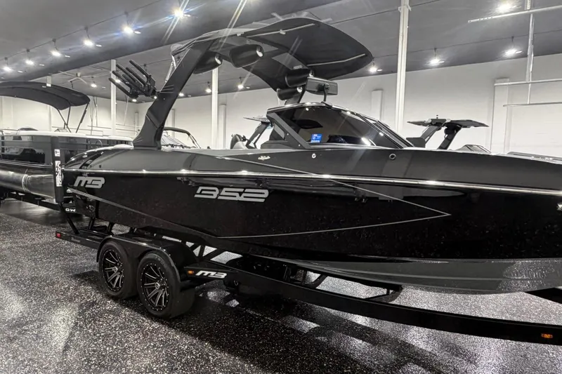 Slide: The Image of 2024 MB B52 23 Classic boat in showroom, sleek black design on trailer. - 7