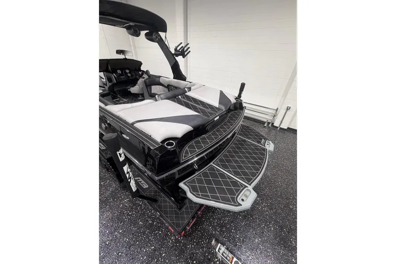 Slide: The Image of 2024 MB B52 23 Classic boat interior with sleek black and gray design in a showroom. - 5