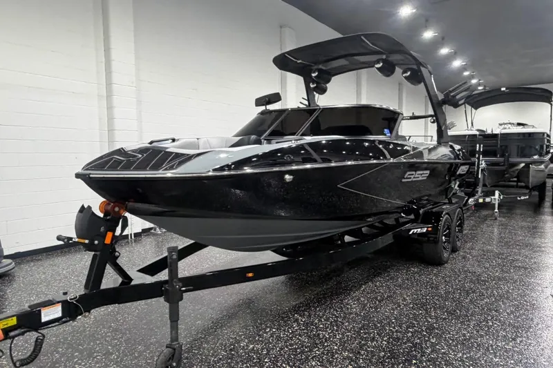 Slide: The Image of 2024 MB B52 23 Classic boat in showroom, sleek black design on trailer. - 3
