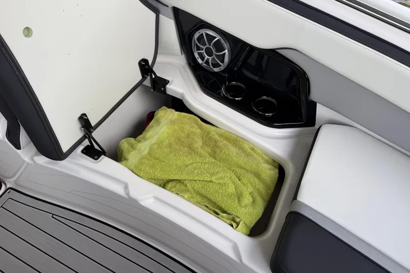 Slide: The Image of Storage compartment in 2022 Yamaha Boats 252SD with towel and cup holders. - 67