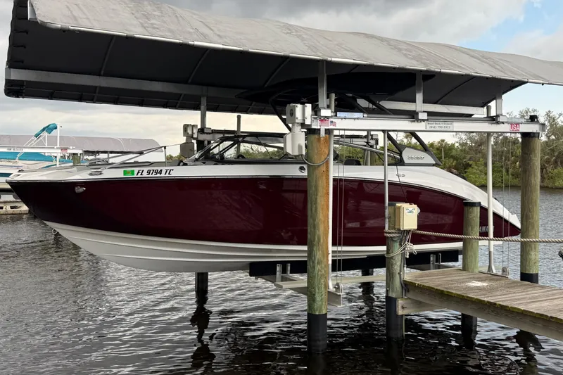 The Image of 2022 Yamaha Boats 252SD on lift, docked at marina under canopy. - 0