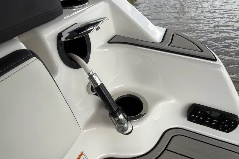 Slide: The Image of 2022 Yamaha Boats 252SD fuel port and control panel by the water. - 12