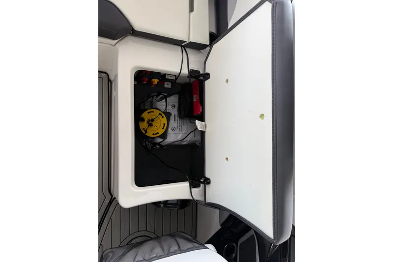 Slide: The Image of Open storage compartment in a 2022 Yamaha Boats 252SD, showcasing internal components. - 22