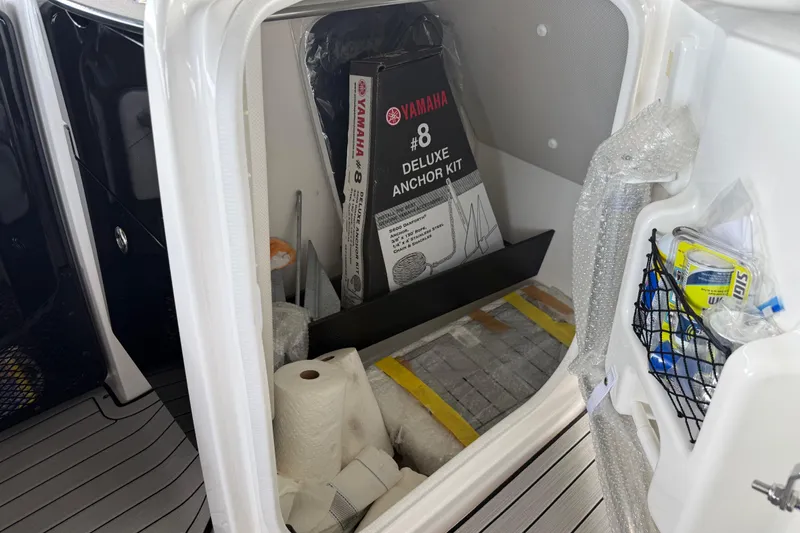 Slide: The Image of Storage compartment of 2022 Yamaha Boats 252SD with anchor kit and supplies. - 50