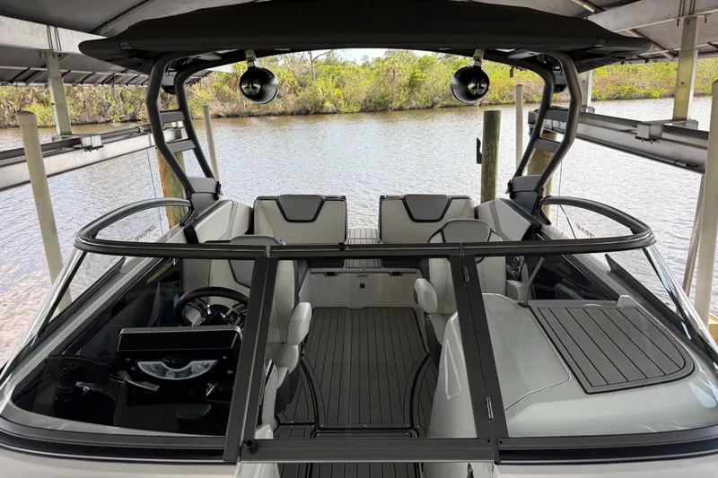 Slide: The Image of 2022 Yamaha Boats 252SD interior view, docked on a serene river. - 53