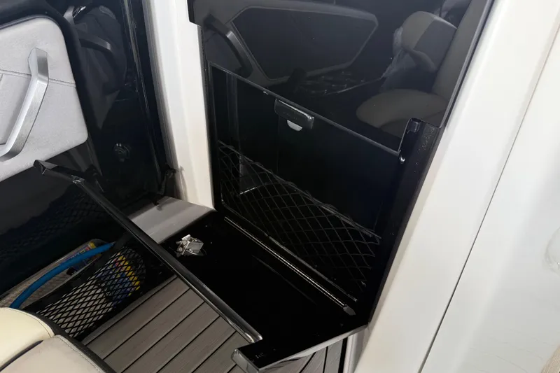Slide: The Image of 2022 Yamaha Boats 252SD interior storage compartment with netting and sleek design. - 33