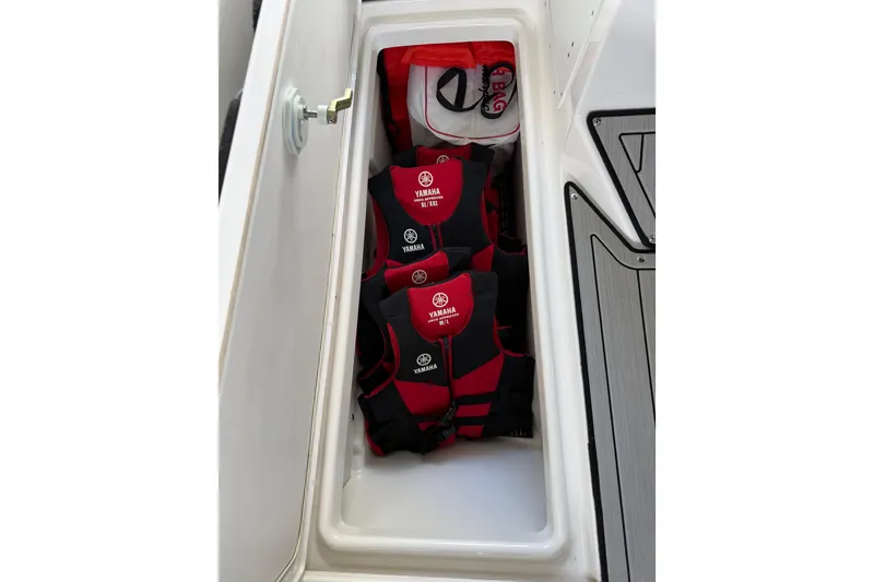 Slide: The Image of Storage compartment on 2022 Yamaha Boats 252SD with life jackets and gear. - 48