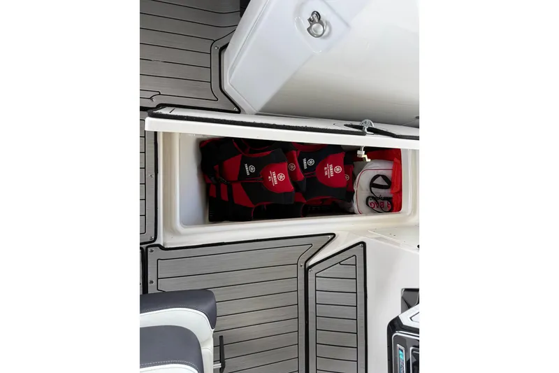 Slide: The Image of 2022 Yamaha Boats 252SD storage compartment with life jackets and gear. - 49