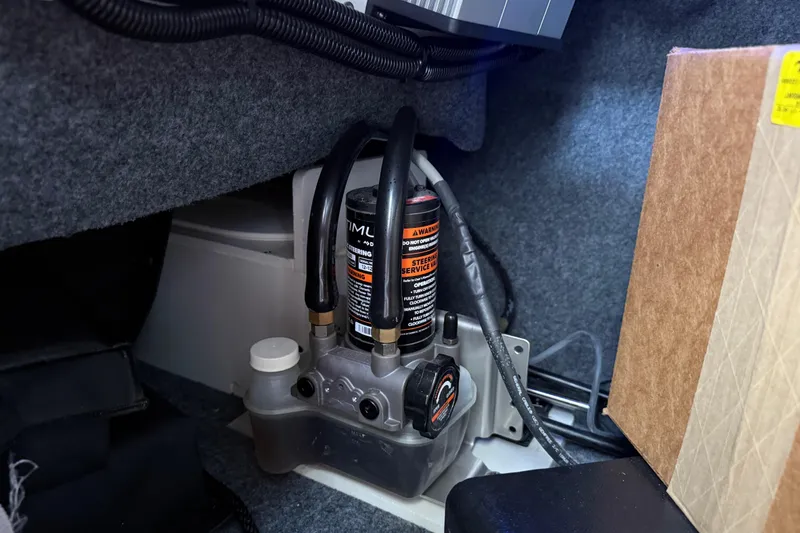 Slide: The Image of 2022 Yamaha Boats 252SD steering system components in a storage compartment. - 63