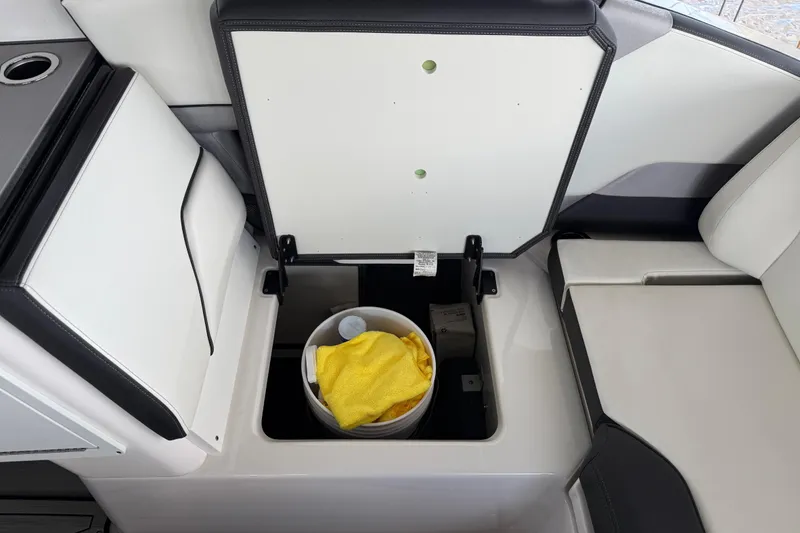 Slide: The Image of 2022 Yamaha Boats 252SD storage compartment with bucket and yellow towel. - 19