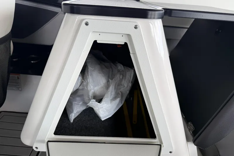 Slide: The Image of Storage compartment in 2022 Yamaha Boats 252SD, featuring a triangular opening with visible contents. - 18