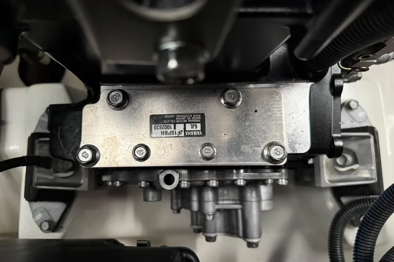 Slide: The Image of Close-up of a 2022 Yamaha Boats 252SD engine component with visible bolts and label. - 72