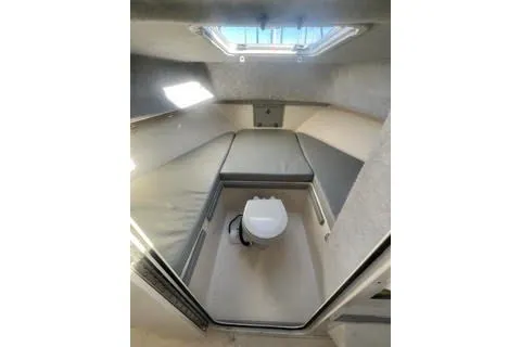 Slide: The Image of 2023 Defiance Guadalupe 290 EX cabin interior with compact toilet and cushioned seating. - 7