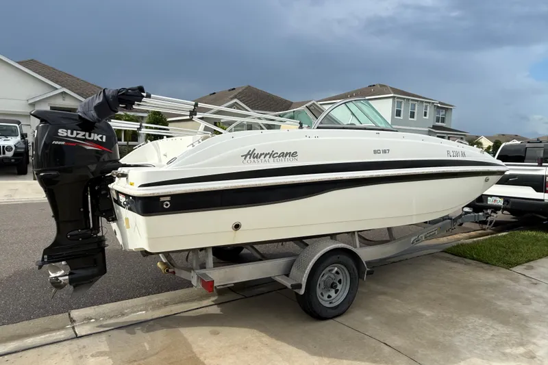 Slide: The Image of 2017 Hurricane SunDeck 187 OB boat on trailer with Suzuki outboard motor in suburban driveway. - 2