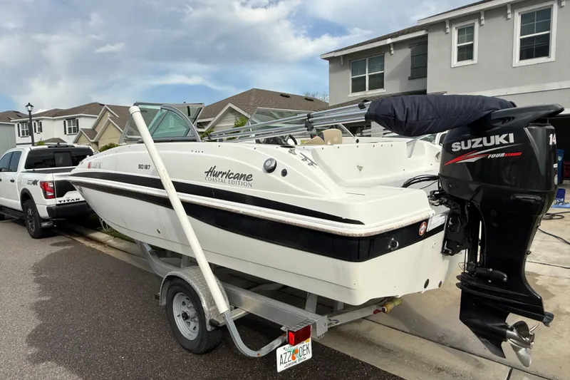 Slide: The Image of 2017 Hurricane SunDeck 187 OB boat with Suzuki outboard motor on trailer in residential area. - 3