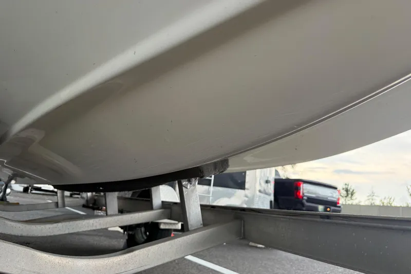 Slide: The Image of 2017 Hurricane SunDeck 187 OB boat on trailer, underside view, parked on road. - 25