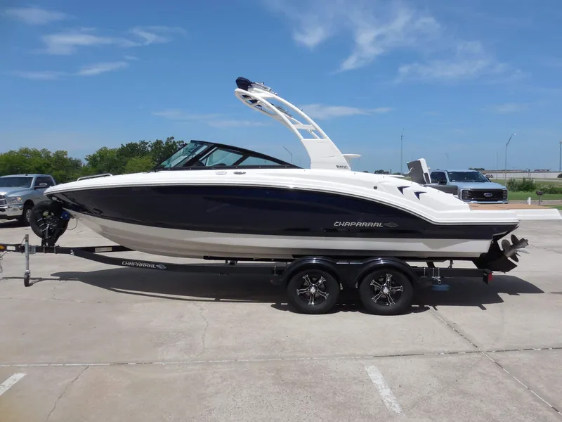 Slide: The Image of Chaparral 23 SSi 2026 on a trailer, white and blue design, parked outdoors. - 6