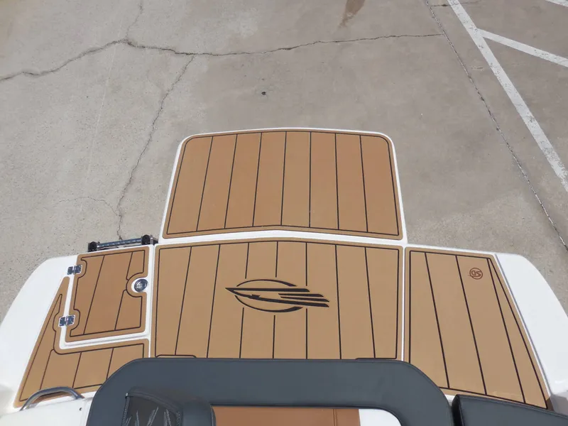 Slide: The Image of The image shows the deck of a Chaparral 23 SSi boat with brown flooring. - 21