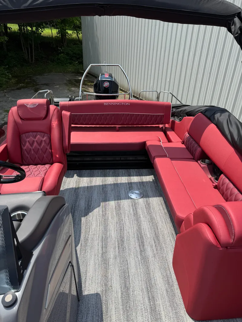 Slide: The Image of The image shows the interior of a 2025 Bennington 26LXSSB boat with red seating. - 7