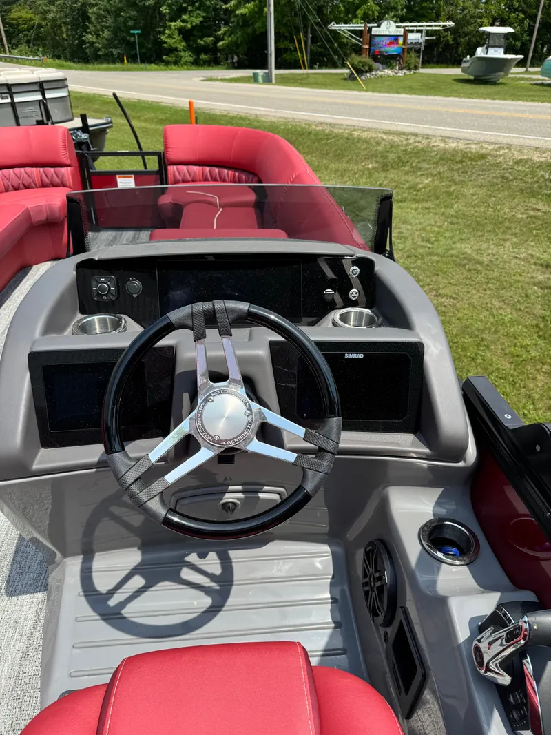 Slide: The Image of The image shows the cockpit of a Bennington 26LXSSB boat with a modern steering wheel and red seats. - 8