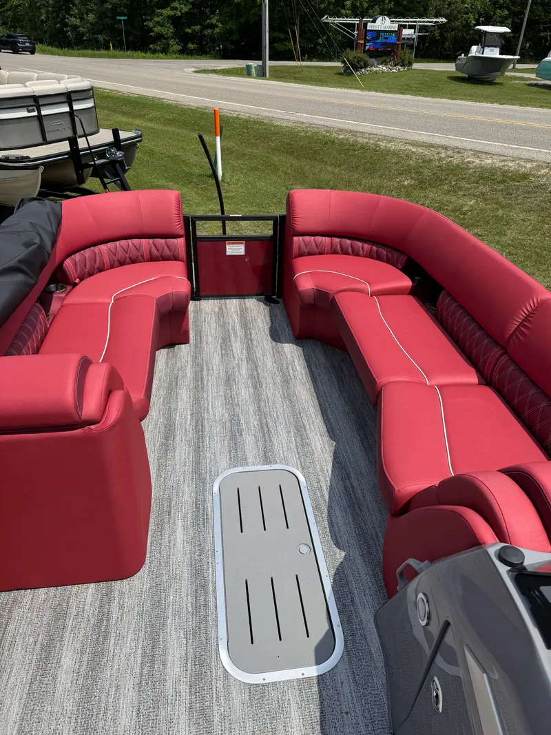 Slide: The Image of The image shows the interior of a Bennington 26LXSSB boat with red seating and gray flooring. - 6