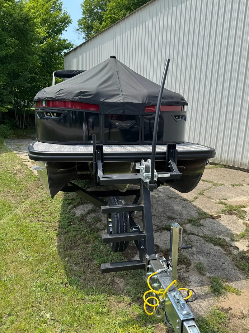 Slide: The Image of A 2025 Bennington 26LXSSB on a trailer beside a building. - 2