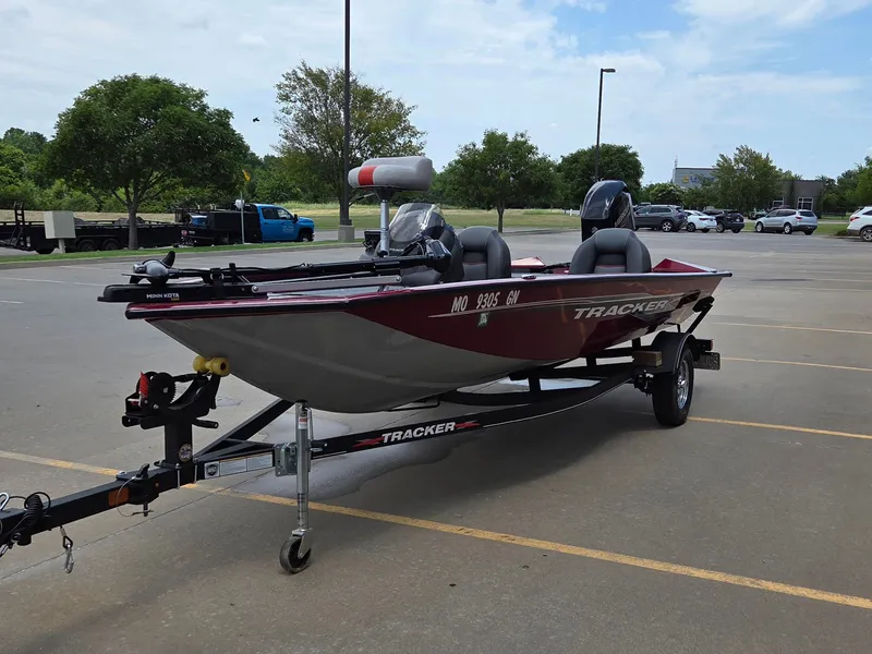 Slide: The Image of A red Tracker boat on a trailer in a parking lot. - 4