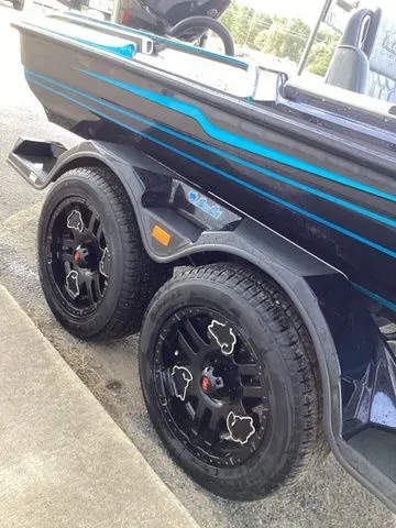 Slide: The Image of A Bass Cat Lynx STS boat on a trailer with stylish black wheels and blue accents. - 34