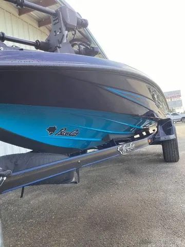 Slide: The Image of A 2026 Bass Cat Lynx STS boat with a blue hull on a trailer. - 19