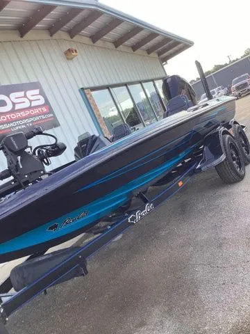 Slide: The Image of A 2026 Bass Cat Lynx STS on a trailer in front of a building. - 17