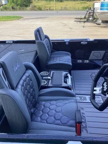 Slide: The Image of The image shows the interior of a Bass Cat Lynx STS boat with cushioned seats and cup holders. - 36