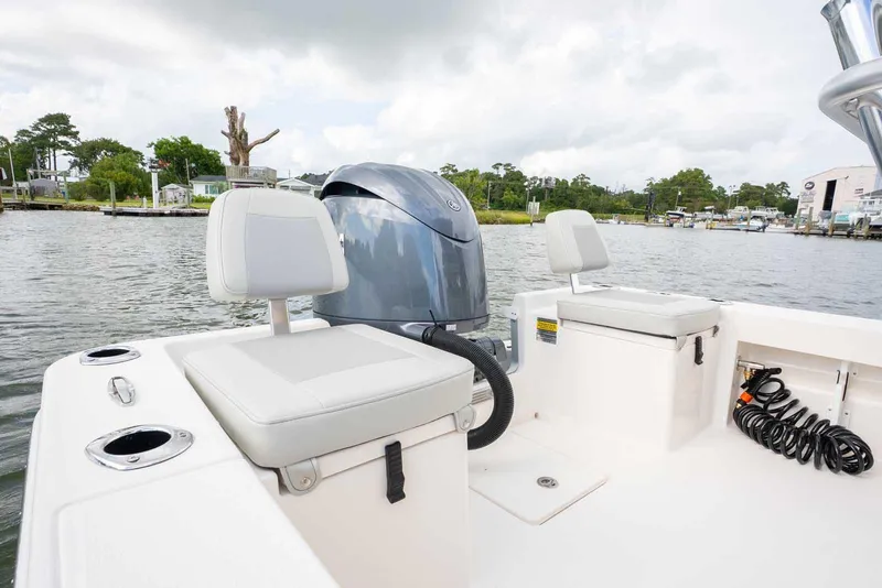 Slide: The Image of 2026 Bay Rider 219 Bay boat interior with seating and motor, dockside view. - 24