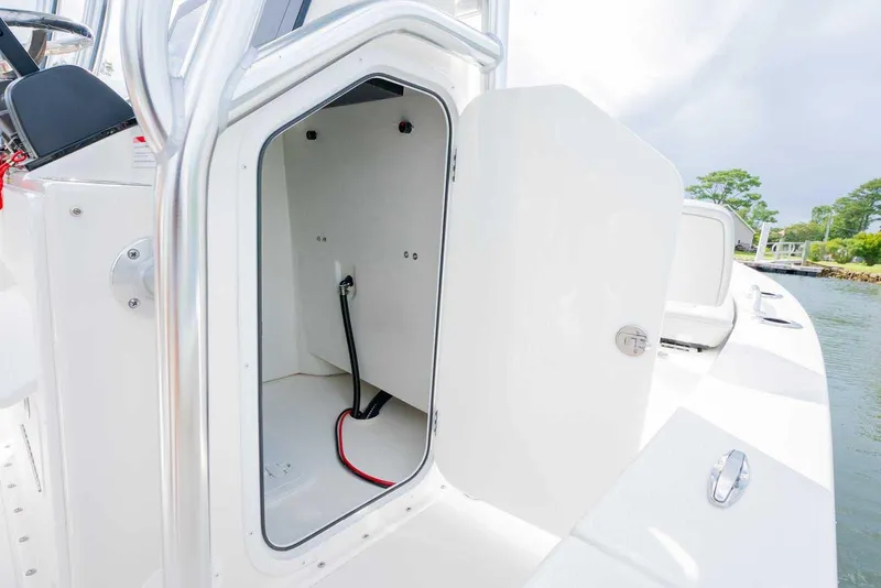 Slide: The Image of 2026 Bay Rider 219 Bay boat storage compartment with open door, showing interior details. - 27