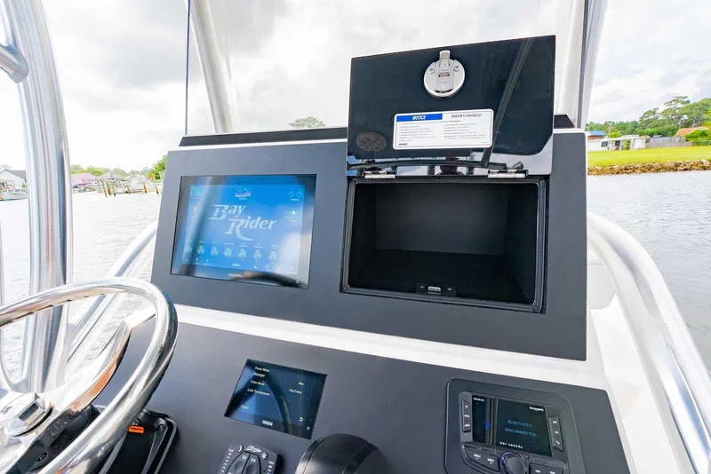 Slide: The Image of 2026 Bay Rider 219 Bay boat dashboard with touchscreen display and storage compartment. - 16