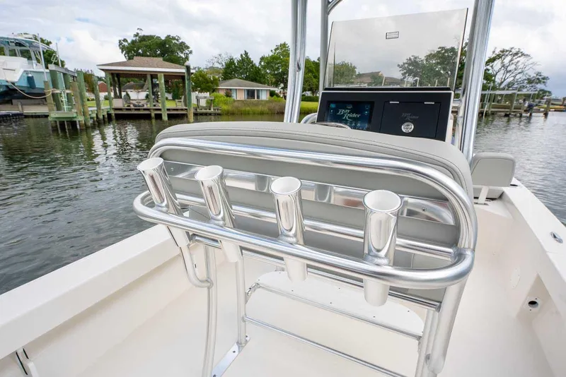 Slide: The Image of 2026 Bay Rider 219 Bay boat with rod holders, docked near waterfront homes. - 26